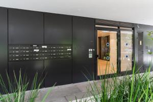 テルアビブにあるBlueground at City Center, Quiet, Parkingの植物のある黒い建物のファサード