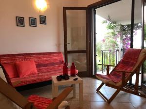 a living room with a couch and a table and chairs at AffittaSardegna - Casa delle Dune in Capo Comino