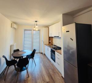 a kitchen with a table and chairs and a refrigerator at Milan Luxury Apartaments X in Târgu-Mureş