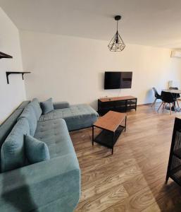 a living room with a blue couch and a table at Milan Luxury Apartaments X in Târgu-Mureş