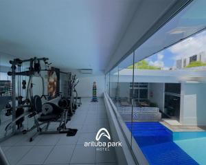 a fitness room with a gym and a swimming pool at Arituba Park Hotel in Natal