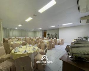 a large banquet hall with tables and chairs in a room at Arituba Park Hotel in Natal