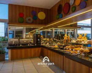 a restaurant with a buffet of food on a counter at Arituba Park Hotel in Natal