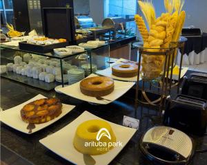 a table with various pastries and pastries on plates at Arituba Park Hotel in Natal