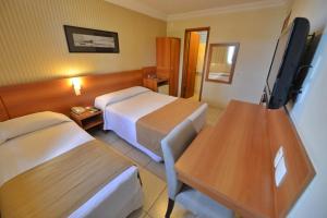 a hotel room with two beds and a flat screen tv at Arituba Park Hotel in Natal