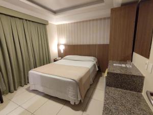 a hotel room with a bed and a bathroom at Arituba Park Hotel in Natal
