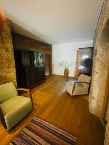a living room with a couch and a chair at Silentium Dolomites Chalet in Monguelfo
