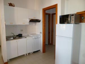 eine Küche mit einem weißen Kühlschrank und einer Spüle in der Unterkunft Casa Bugarini in Marcelli