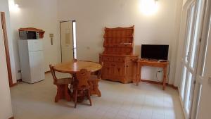 eine Küche mit Tisch und Schreibtisch und Kühlschrank in der Unterkunft Casa Bugarini in Marcelli