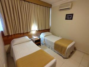 a hotel room with two beds and a table at Arituba Park Hotel in Natal