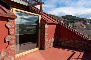 a window on the side of a red brick building at Ático con terraza en Moaña in Moaña