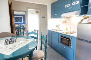 a blue kitchen with a table and a sink at Kalian Meteora in Kalabaka
