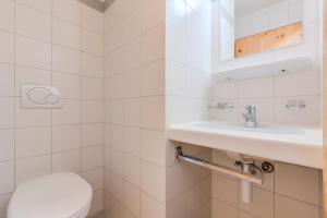 a white bathroom with a toilet and a sink at Pracondu 1 304 - OUTDOOR & FUN charming apartment in Nendaz