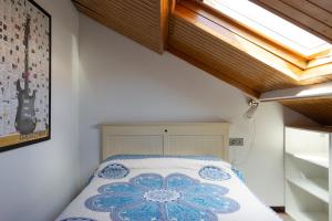 a bedroom with a bed with a flower on it at Ático con terraza en Moaña in Moaña +10 photos