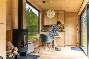 a woman standing in the kitchen of a tiny house at Ecopark Twente Cabin Tilligte in Tilligte