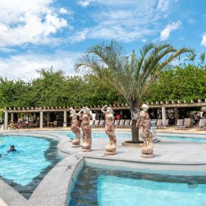 a swimming pool with statues in the middle of it at Lacqua diRoma - Serviço de Hotelaria in Caldas Novas