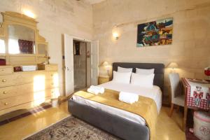 Un dormitorio con una cama grande con toallas. en Birgu Square Townhouse, Rooftop & 3 Bathrooms, en Birgu
