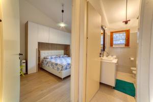 a bedroom with a bed and a bathroom with a sink at SulMare Apartment in Stintino