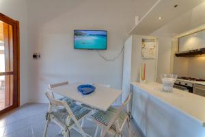 a kitchen with a white table and two chairs at SulMare Apartment in Stintino