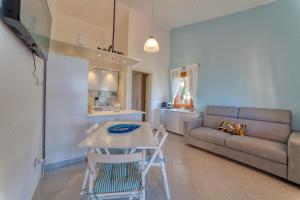 a living room with a table and a couch at SulMare Apartment in Stintino