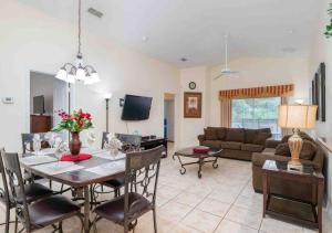 ein Wohnzimmer mit Tisch und Couch in der Unterkunft 5 bedroom, 7 bed , 3 bathroom Midterm Rental Home with Pool and Game room, near Disney in Davenport