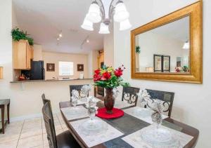 ein Esszimmer mit Tisch und Spiegel in der Unterkunft 5 bedroom, 7 bed , 3 bathroom Midterm Rental Home with Pool and Game room, near Disney in Davenport
