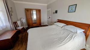 a bedroom with a large white bed with a wooden headboard at Le chalet des apiculteurs in Folles