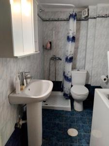 a small bathroom with a sink and a toilet at Spacious apartment Nantia's apartment in Hanioti +23 photos