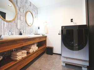 a bathroom with a sink and a large television at Little Deer by SANA in Tateyama +31 photos