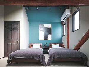 a bedroom with two beds and a blue wall at Little Deer by SANA in Tateyama +31 photos