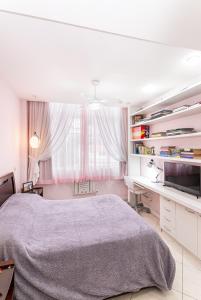 リオデジャネイロにあるPraia do Lemeのベッドと机と窓のある寝室