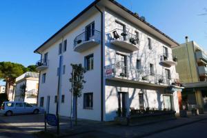 un bâtiment blanc avec des balcons sur le côté dans l'établissement Apartments in Bibione 45652, à San Michele al Tagliamento