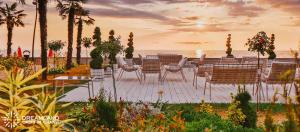 een groep stoelen en tafels met de oceaan op de achtergrond bij Dreamland oasis in Chakvi +2 foto's