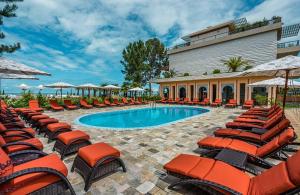 een zwembad met stoelen en parasols naast een gebouw bij Dreamland oasis in Chakvi
