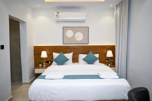 a bedroom with a large white bed with blue pillows at شقق لافيدا الفندقية in Riyadh +29 photos