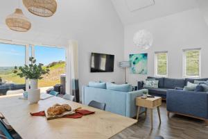 a living room with a table and blue furniture at No 5 The Vista, Willingcott, Woolacombe in Woolacombe