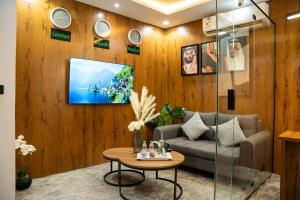 a living room with a tv on a wooden wall at شقق لافيدا الفندقية in Riyadh