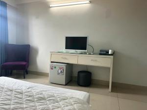 a desk with a computer on it next to a bed at Nhà Nghỉ Gia Anh in An Dương +6 photos