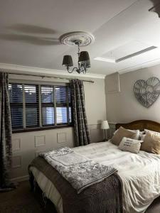 a bedroom with a bed and a clock on the wall at The Garden Rooms at Woody's in Abergele