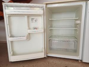 an empty white refrigerator with its door open at Ruhige Ortsrandlage 2 in Kiel