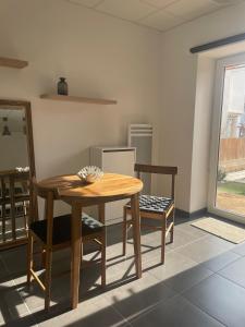 a kitchen with a wooden table and two chairs at Chez Ambre et Lulu - Appartement centre ville avec piscine in Millau