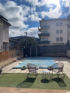 two chairs and a swimming pool in a backyard at Chez Ambre et Lulu - Appartement centre ville avec piscine in Millau