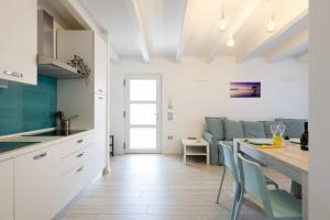 a kitchen and living room with a table and chairs at Conca d'Oro Apartments, appartamento 5 e 6 in Arco
