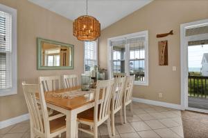 een eetkamer met een tafel, stoelen en een kroonluchter bij 3739 Island Drive - Happy Ours in Thomas Landing