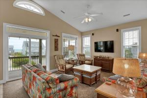 een woonkamer met een bank en een tv bij 3739 Island Drive - Happy Ours in Thomas Landing +39 foto's