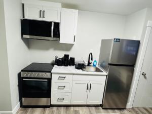 a small kitchen with a stove and a refrigerator at True Haven in Prince George