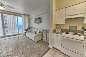 巴拿马城海滩Sunset at The Shores的厨房以及带沙发和炉灶的客厅。