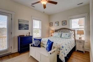 a bedroom with a bed and a dresser and windows at 2701- A S Shore Drive - Threefoot in Surf City