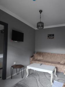 una sala de estar con un sofá y una mesa en maneviga pansiyon, en Çaykara