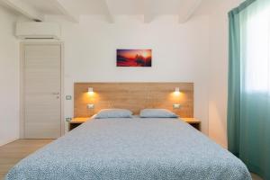 a bedroom with a large bed with two pillows at Conca d'Oro Apartments, appartamento 5 e 6 in Arco
